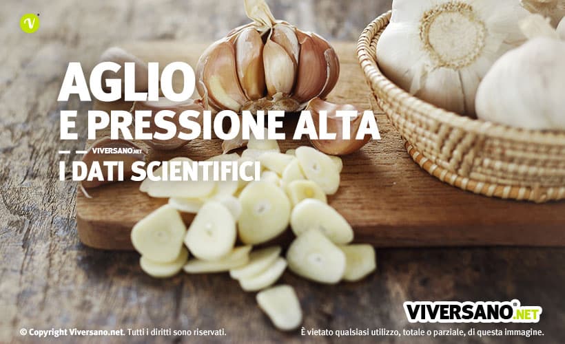 Aglio tagliato a fette sopra un tagliere di legno