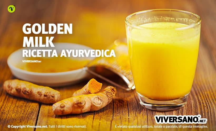 Bicchiere di Golden Milk con curcuma fresca sopra un tavolo